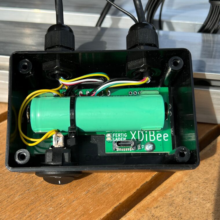 Das geöffnete Gehäuse der WLAN-Waage von innen: der Akku liegt mittig, rechts daneben der USB-C-Anschluss, darüber die beiden Leuchten mit der Aufschrift LADEN und FERTIG.